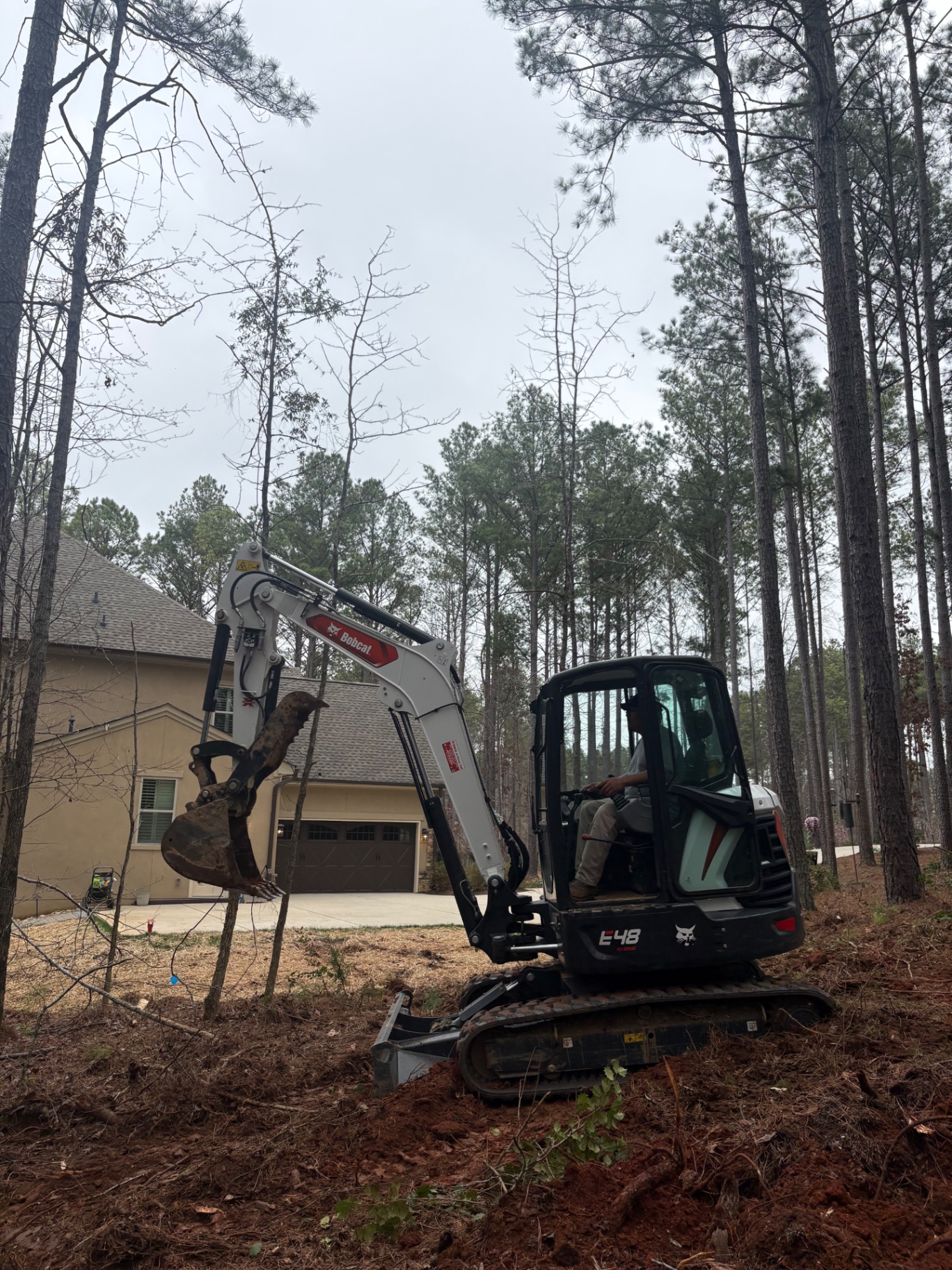 Bobcat E48 excavator on a land clearing job site
