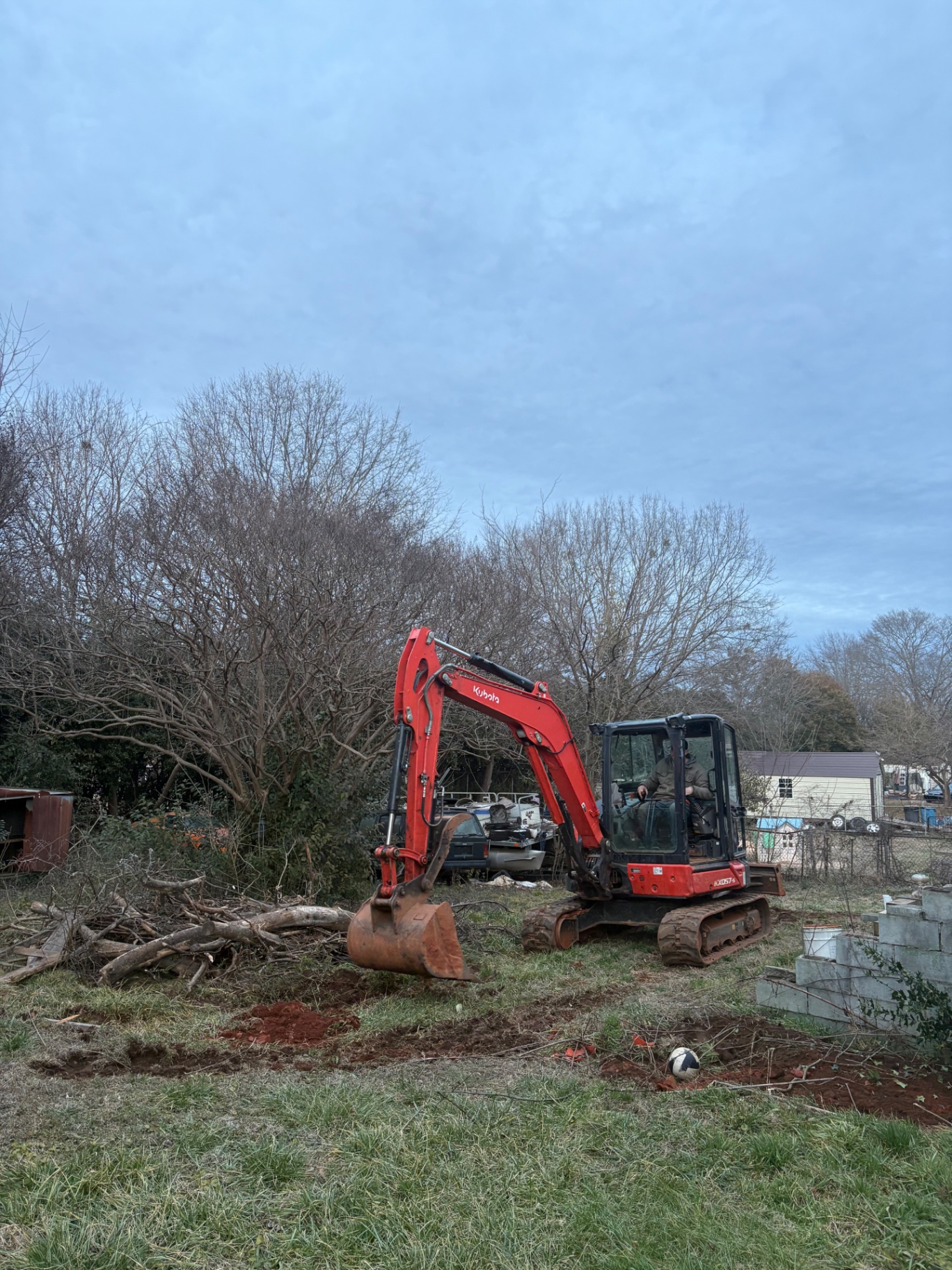 Kubota mini excavator digging on a residential land clearing project