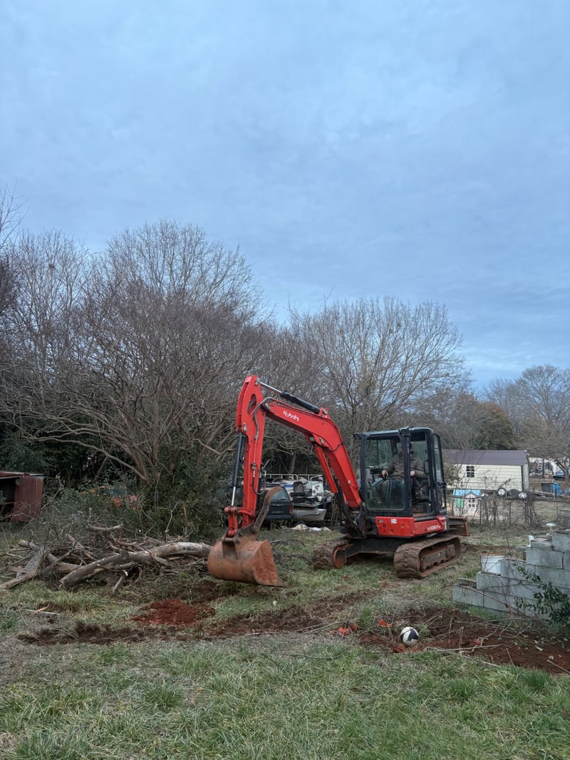 Kubota mini excavator digging on a residential land clearing project