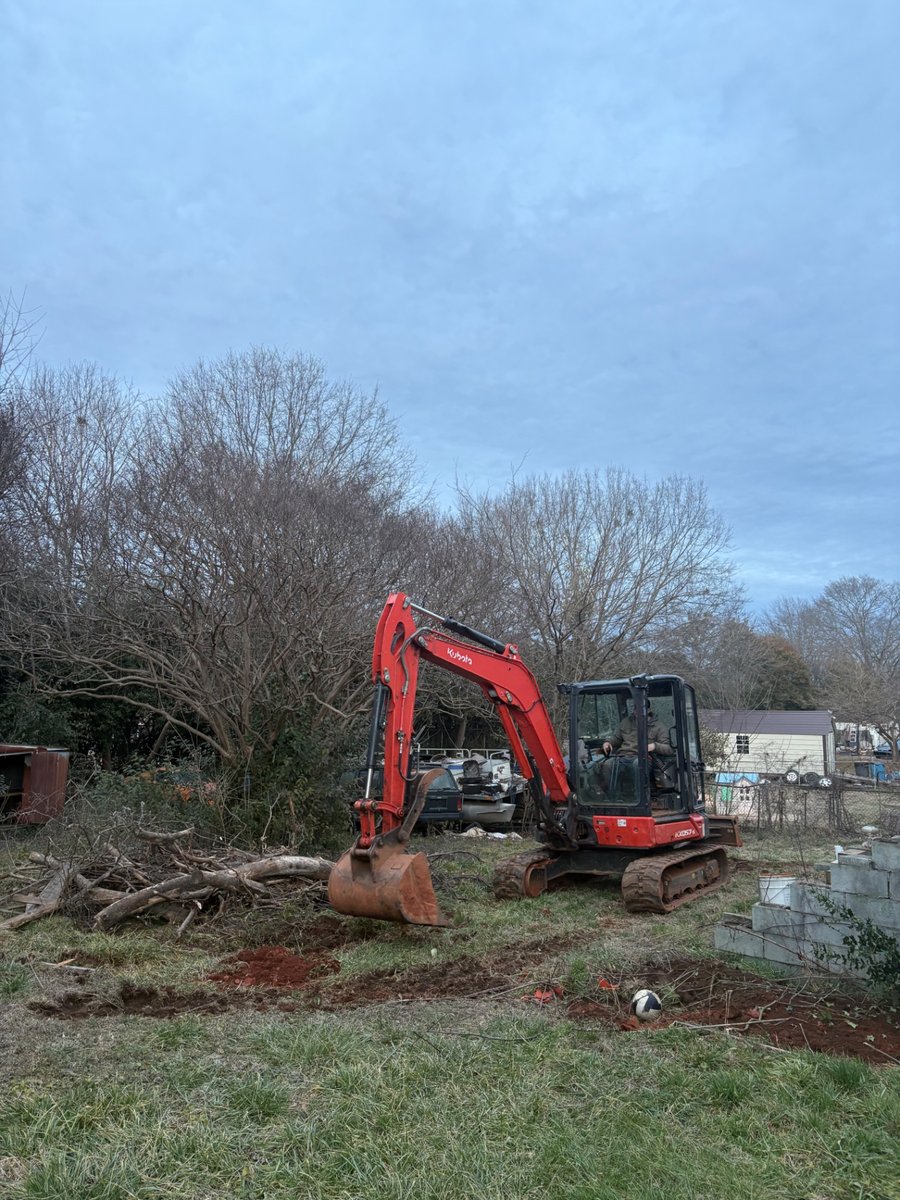 Kubota mini excavator digging on a residential land clearing project